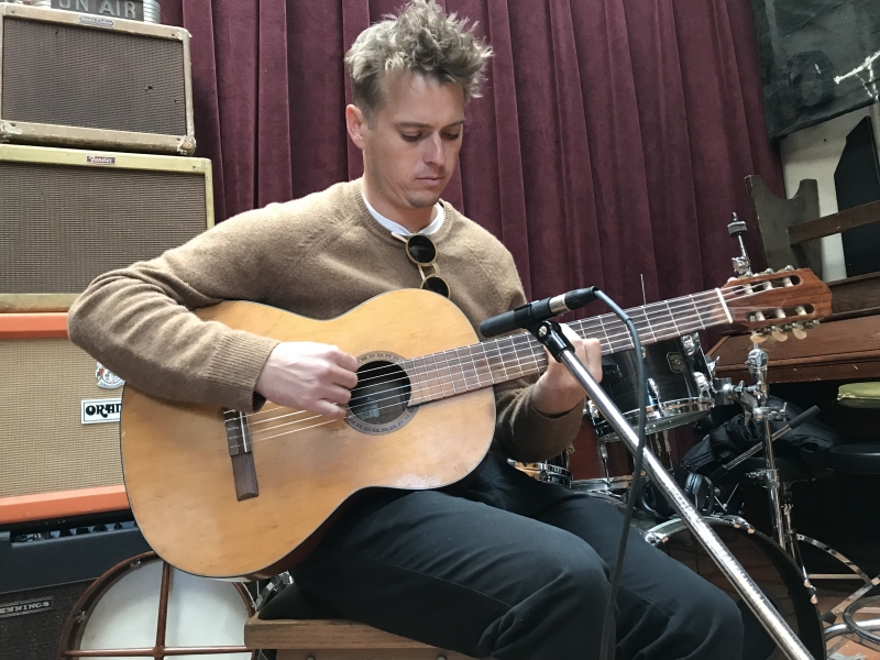 A photo of Ross Howe playing guitar at Wide Hive Records in Berkeley, California.